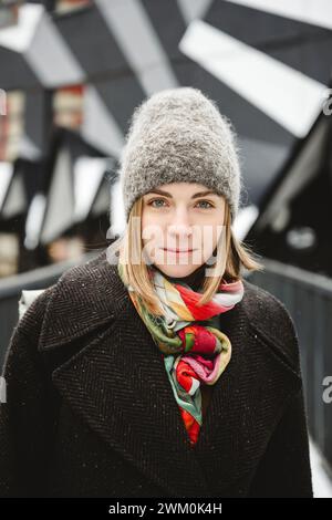 Lächelnde junge Frau in warmer Kleidung Stockfoto