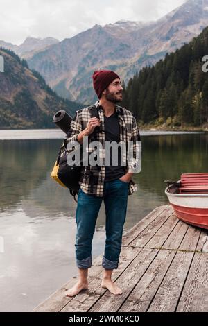 Junger Mann, der auf der Pier am Vilsalpsee in Tirol steht Stockfoto