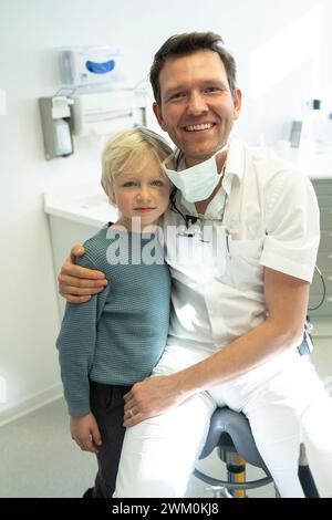 Lächelnder Zahnarzt mit Junge in der Klinik Stockfoto