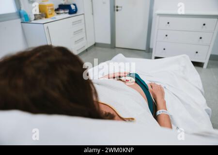 Schwangere Frau, die im Krankenhaus auf dem Bett liegt Stockfoto