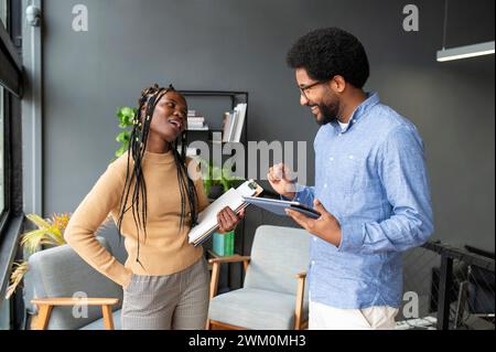 Lächelnder Geschäftsmann und Geschäftsfrau diskutieren im Büro Stockfoto