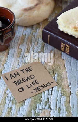 Ich bin das Brot des Lebens - Jesus Christus, handgeschriebener Text mit heiligem Bibelbuch und einer Tasse Wein. Christliches Pascha, spirituelles Essen und Trinken. Stockfoto