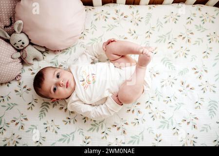 Nettes Baby Mädchen liegen in Krippe zu Hause Stockfoto