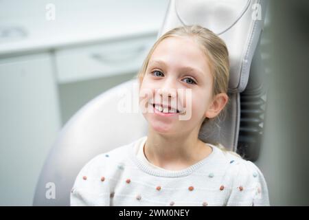 Lächelnde Mädchen sitzen auf dem Zahnarztstuhl an der Klinik Stockfoto