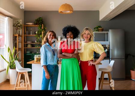 Glückliche multirassische Freunde stehen zu Hause in der Küche Stockfoto