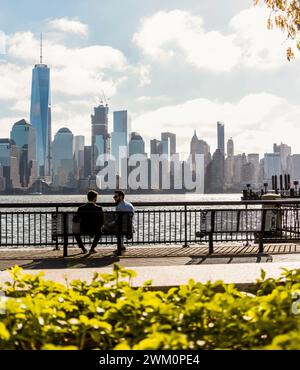 Junge Geschäftskollegen sitzen auf einer Bank an der Promenade in der Stadt Stockfoto