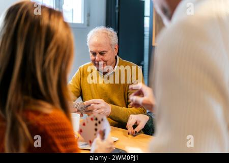 Freunde, die zu Hause Karten spielen Stockfoto