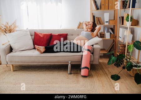 Schwangere Frau entspannt sich auf dem Sofa zu Hause Stockfoto