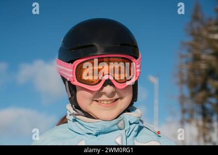 Lächelndes Mädchen mit Skibrille im Resort Stockfoto