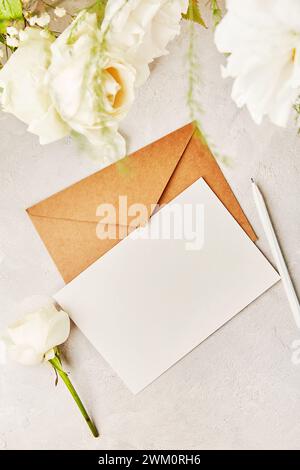 Beigefarbener Bastelpapierumschlag für Grüße, Einladung, Postkarte, Text zwischen weißen Blumen. Biophile Einrichtung, gemütliches Zuhause. Kopierbereich Stockfoto