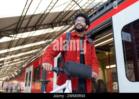 Ein nachdenklicher Mann hält den Fahrradgriff in der Nähe des Bahnhofs Stockfoto