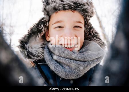 Glücklicher Junge, der im Winter eine Jägermütze trägt Stockfoto
