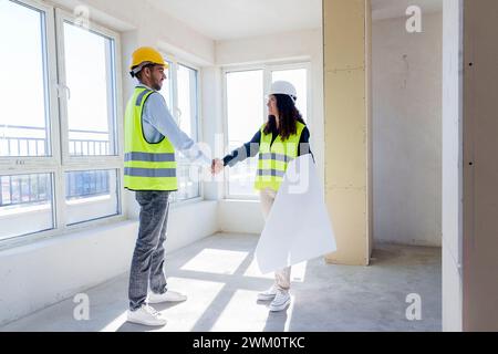 Multirassische Ingenieure schütteln sich die Hand auf der Baustelle Stockfoto