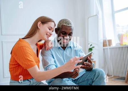 Glückliches Paar, das zu Hause einen Tablet-PC verwendet Stockfoto