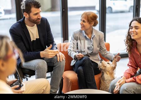 Geschäftsmann im Rollstuhl diskutiert Strategie mit Kollegen im Büro Stockfoto