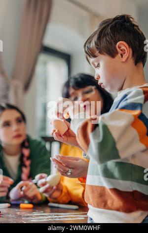 Glückliche Familie, die zu Hause mit Ostereiern sitzt Stockfoto