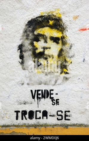 TOMAR, PORTUGAL - 28. APRIL 2015: Che Guevara Graffiti an der alten Hauswand und Text auf Portugiesisch „zum Verkauf, zum Austausch“. Stockfoto