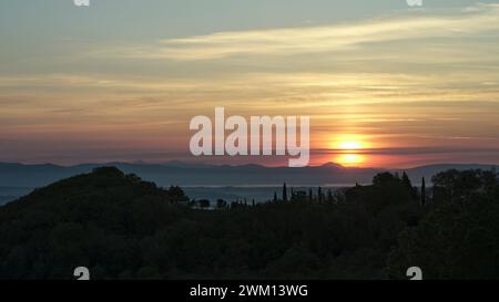 Doppelter Sonnenaufgang über hügeliger, nebeliger Landschaft, Toskana, Italien Stockfoto