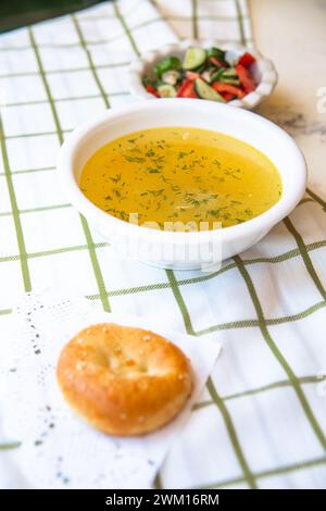Usbekische Nationalgerichte, Plov, Shurpa, Salat und nicht auf einem Tablett mit Tee. Traditionelle usbekische Küche. Hintergrund mit kariertem Tischtuch. Stockfoto