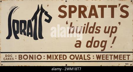 Emaillewerbung aus den 1930er Jahren Spratt's Hundefutter. Spratts baut einen Hund auf. Schöne Illustration eines Terrierhundes, hergestellt aus den Buchstaben des Namens Spratts, ikonisches Design-Logo, bekannt als Kalligramm. Hersteller von Bonio, Mixed Ovals und Weetmeet. Emailschilder wurden von den Herstellern geliefert, um an Ladenfronten zu befestigen, um Waren zu werben. Sie sind aus Metall gefertigt und sind robust und langlebig, als Produkte viel länger als heute in der Herstellung waren. Heute sind diese emaillierten Schilder in hohem Maße sammelbar und sogar gefälscht. Stockfoto