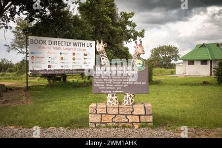 Schilder für Hotels und Lodges und kostenloses wifi neben einem Toilettenblock am Haupteingang des Mikumi-Nationalparks in Tansania. Stockfoto