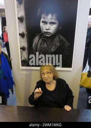 4070630 Paris, November 2014, Salon de la Photo. Die in Frankreich und der Schweiz geborene Fotografin Sabine Weiss sitzt vor ihrem Werk (Little Beggar, Toledo, Spanien, 1950) (Foto); (add.info.: Paris; Parigi, Frankreich; Francia, Paris Expo Porte de Versailles Parigi, Novembre 2014, Salon de la Photo. la fotografa franco-svizzera Sabine Weiss seduta davanti a una sua Opera (Piccolo mendicante, Toledo, Spagna, 1952)); © Marcello Mencarini. Alle Rechte vorbehalten 2024. Stockfoto