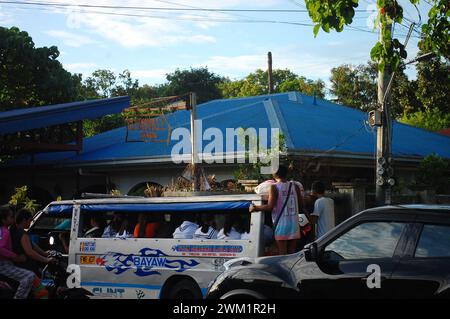 Iloilo Verkehrsstau. Ein Mann hängt im Jeepney, weil er voll sitzt. Diese Situation ist auf den Philippinen sehr häufig Stockfoto