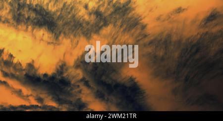 Goldener Sonnenuntergangshimmel mit dramatischen dunklen Wolken. Dunkle Wolken stehen im Kontrast zu einem hellen, goldenen Himmel. Stockfoto