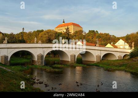 Wunderschönes altes Schloss mit einer Brücke über den Fluss bei Sonnenuntergang. Alte europäische Architektur. Namest nad Oslavou - eine Stadt in der Tschechischen Republik. Stockfoto