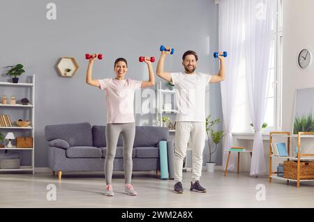 Glückliches Paar, Das Zu Hause Mit Kurzhanteln Sport Treiben Wollte Stockfoto