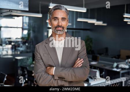 Selbstbewusster älterer Geschäftsmann mittleren Alters, der im Büro die Kamera ansieht, Porträt. Stockfoto