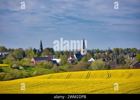 Blick auf ratingen homberg über Rapsfeld im Frühling und wolkenblauem Himmel Stockfoto