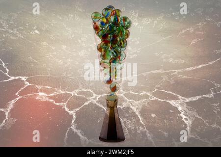 Nahaufnahme eines Champagnerglases gefüllt mit Glasmarmor isoliert vor farbigem Hintergrund Stockfoto