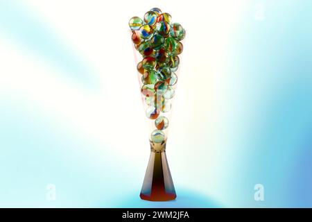 Nahaufnahme eines Champagnerglases gefüllt mit Glasmarmor isoliert vor farbigem Hintergrund Stockfoto