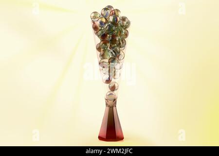 Nahaufnahme eines Champagnerglases gefüllt mit Glasmarmor isoliert vor farbigem Hintergrund Stockfoto