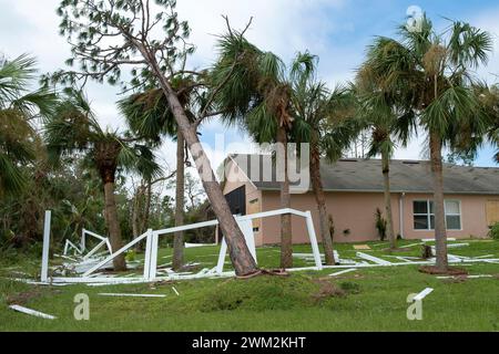 Hurrikanschäden am weißen PVC-Hinterhof-Zaun wurden zerstört, nachdem Baumschutt in Florida darauf gefallen war. Stockfoto