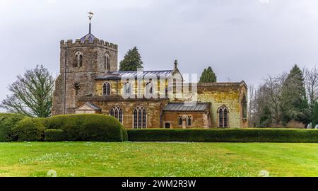 Ein Blick über ein Feld in Richtung der All Saints Kirche aus dem 18. Jahrhundert in Lamport, Northamptonshire, Großbritannien an einem Wintertag Stockfoto