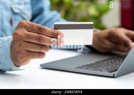 Nahaufnahme eines Mannes, der online mit einer Kreditkarte und einem Laptop im E-Commerce-Konzept kauft Stockfoto