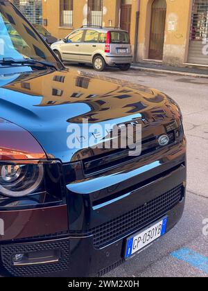 Cremona, Italien - 15. Februar 2024 Land Rover Defender 130 SE Sedona Red suv geländewagen in Parkposition. Stockfoto