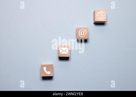 Website und Internet Kontaktieren Sie uns Seitenkonzept mit Telefon-, Chat-, E-Mail- und E-Mail-Symbolen. Kontaktieren Sie uns Icon Telefon, Chat, E-Mail, Post auf Wood Cube. Stockfoto