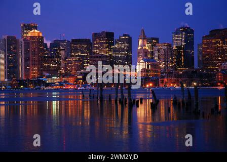 Die Lichter der Skyline von Boston spiegeln sich im eisigen Wasser des Hafens Stockfoto