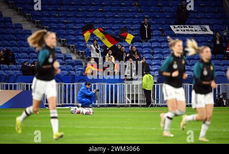 Lyon, Frankreich. Februar 2024. Fußball: Nationalmannschaft, Frauen, Olympische Spiele, Frankreich - Deutschland, Play-off-Runde, Halbfinale, Groupama Stadium. Deutsche Fans jubeln, während sich die deutschen Spieler vor dem Spielbeginn aufwärmen. Quelle: Sebastian Christoph Gollnow/dpa/Alamy Live News Stockfoto