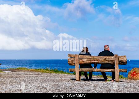 Ein Paar sitzt auf einer Bank auf der Klippe. Zumaya, Guipúzcoa, País Vasco, Spanien, Europa Stockfoto