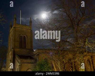 Sheerness, Kent, Großbritannien. Februar 2024. Wetter in Großbritannien: Der fast volle Schneemond über der Heiligen Dreifaltigkeitskirche in Sheerness, Kent heute Abend. Quelle: James Bell/Alamy Live News Stockfoto