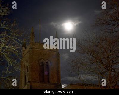 Sheerness, Kent, Großbritannien. Februar 2024. Wetter in Großbritannien: Der fast volle Schneemond über der Heiligen Dreifaltigkeitskirche in Sheerness, Kent heute Abend. Quelle: James Bell/Alamy Live News Stockfoto