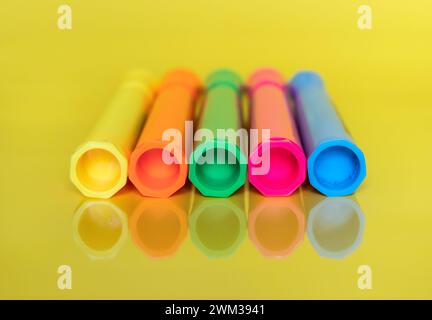 Farbige fluoreszierende Textmarker auf hellgelbem Hintergrund Stockfoto