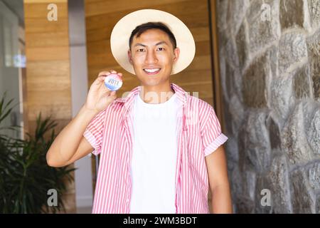 Ein junger asiatischer Mann zeigt stolz ein Abzeichen Stockfoto