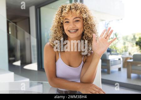 Eine junge birassische Frau lächelt bei einem Videoanruf herzlich zu Hause Stockfoto