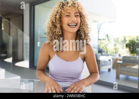 Die junge Frau lacht fröhlich zu Hause bei einem Videoanruf Stockfoto