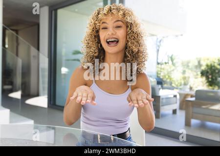 Die junge Frau lacht fröhlich zu Hause bei einem Videoanruf Stockfoto